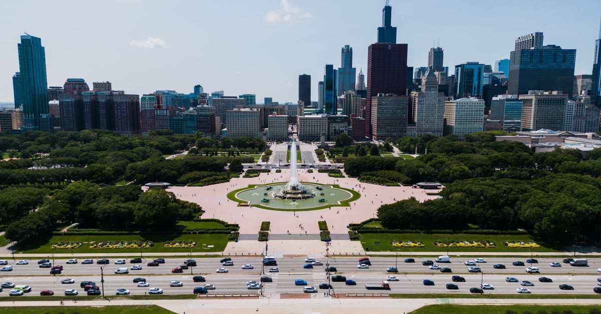 Aerial view of Buckingham Fountain with Chicago skyline in the background, vibrant summer day.